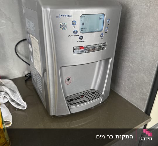מכשיר מים חמים וקרים על משטח מטבח